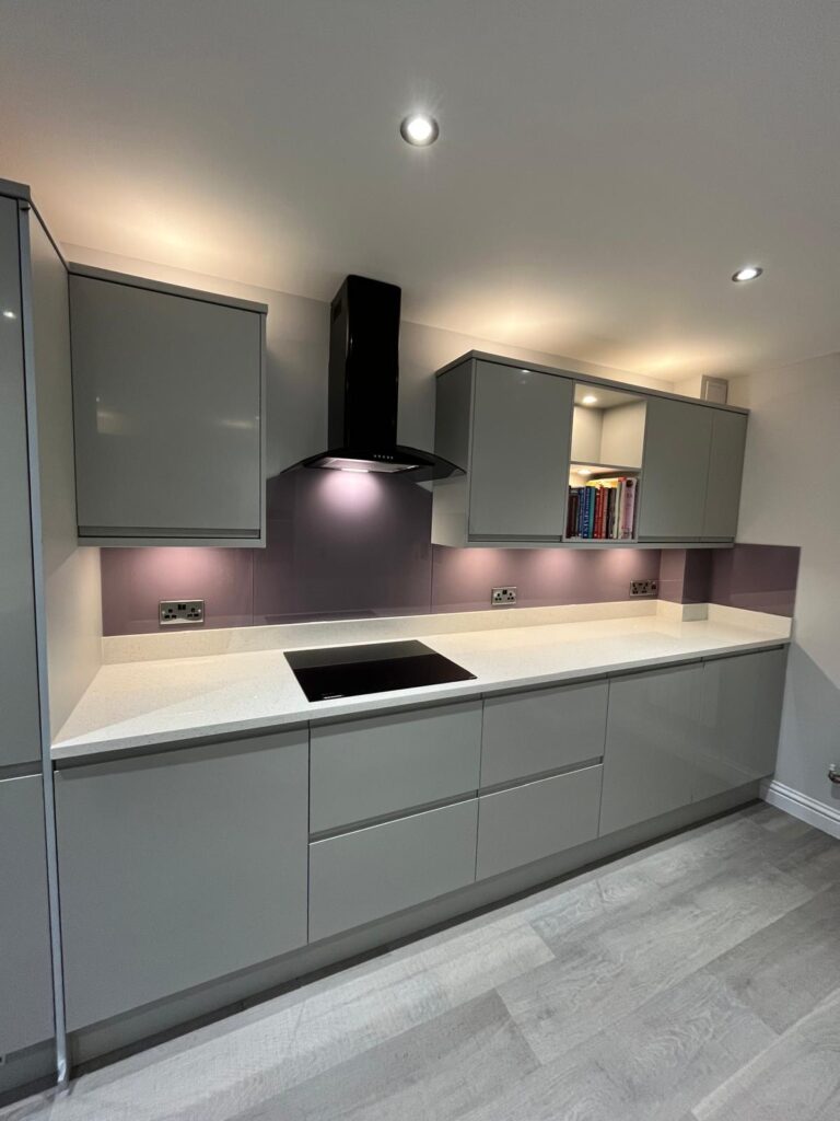 Painted purple glass splashback fitted behind hob in classic shaker-style kitchen
