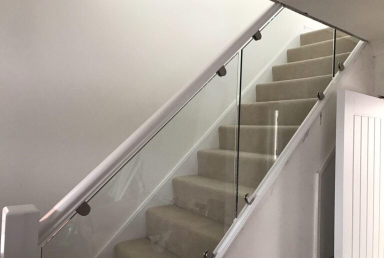 Frameless glass balustrade fitted along staircase with oak handrail